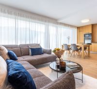 Wohnzimmer in einem Einfamilienhaus mit Sofa, Esstisch und Holzboden.