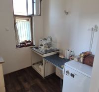 Küche in einer 2-Zimmer-Wohnung mit Geräten und Boden in Holzoptik.