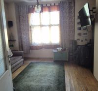 Ein Zimmer in einer 2-Zimmer-Wohnung mit einem Holzboden und einem Fernseher an der Wand.