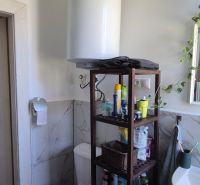 Das Badezimmer in der 2-Zimmer-Wohnung enthält eine Toilette, ein Regal und ein Waschbecken.