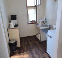 Küche in einer 2-Zimmer-Wohnung mit Holzboden und einfacher Ausstattung.