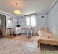 In einem Einfamilienhaus gibt es ein einfaches Zimmer mit einer Kochnische und einem Sessel.