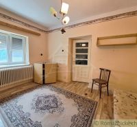 Ein Zimmer in einem Einfamilienhaus mit einem Boden in Holzoptik, hellen Wänden und einem Teppich.