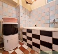 Badezimmer in einem Einfamilienhaus mit Waschbecken und Badewanne, gefliest.
