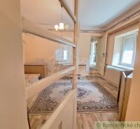 Innenraum eines Einfamilienhauses mit Holzboden, Teppich und Kronleuchter.