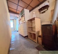 Ein enger Flur in einem Einfamilienhaus mit Gasofen, Regalen und einem Schrank.