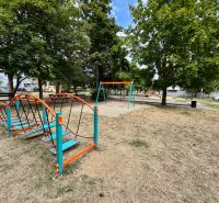 Spielplatz in Topoľčany mit verschiedenen Attraktionen und Bänken im Park.