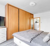 Schlafzimmer in einer 2-Zimmer-Wohnung mit Holzboden und Einbauschrank.