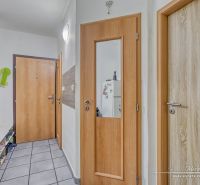 Flur in einer 2-Zimmer-Wohnung mit Fliesenboden und Holztüren.