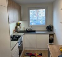 Küche in einer 3-Zimmer-Wohnung mit Holzboden und großem Fenster.