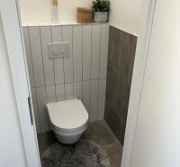 Badezimmer in einer 3-Zimmer-Wohnung mit Stauraum und Dekoration auf dem Regal.