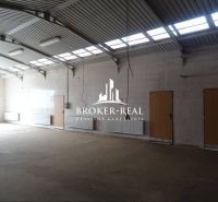 Ein Raum mit hoher Decke und viel natürlichem Licht in einem Gebäude mit Lagern und Hallen.