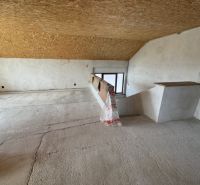 Dachboden eines Einfamilienhauses mit Holzbalkendecke und Blick auf das Innere der Treppe.
