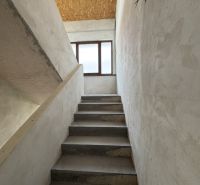 Eine Betontreppe führt zu einem Fenster, Decke aus OSB-Platten, Einfamilienhaus.