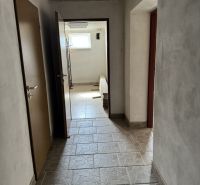 Flur in einem Einfamilienhaus mit Fliesen und Fenster, ohne sichtbare Möbel.