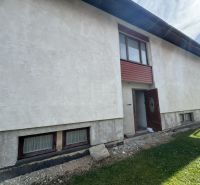 Ein Einfamilienhaus in Plavnica mit hellem Putz und Holzfenstern im Erdgeschoss.
