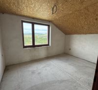 Ein Blick in einen leeren Raum eines Einfamilienhauses mit Dachfenster und Betonboden.