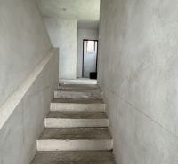 Betontreppen, die in einem Einfamilienhaus in den ersten Stock führen, mit verputzten Wänden.