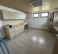 Küche in einem Einfamilienhaus mit Fliesen und einer Küchenzeile in Holzoptik.
