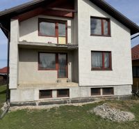 Ein Einfamilienhaus in Plavnica mit einer einfachen Fassade und neuen Fenstern, mit einem grasbewachsenen Grundstück.