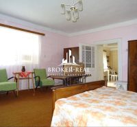 Ein Zimmer in einem Einfamilienhaus mit Möbeln und einem Bett, Boden mit Teppichdekor.