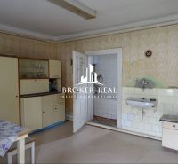 Küche in einem Einfamilienhaus mit Vintage-Möbeln und Spülbecken, Boden mit Holzdekor.