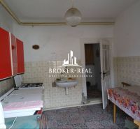 Eine Küche in einem Einfamilienhaus mit gemusterten Fliesen und roten Schränken.