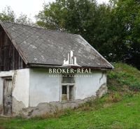 Ein kleines Familienhaus in Černochov mit einem Holzdach und einer vernachlässigten Fassade.