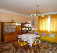 Wohnzimmer in einem Einfamilienhaus mit Retro-Möbeln und gelben Vorhängen.