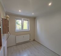 Ein Zimmer in einer 3-Zimmer-Wohnung mit einem Boden in Holzoptik, einer Wandleuchte und einem Heizkörper.