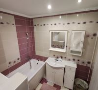 Badezimmer mit Duschwanne und weißen Möbeln in einer 3-Zimmer-Wohnung.