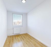 Ein Zimmer in einer 3-Zimmer-Wohnung mit einem Boden in Holzoptik und weißen Wänden.
