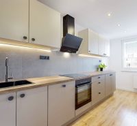 Die Küche in der 3-Zimmer-Wohnung hat einen Boden mit Holzdekor und moderne Ausstattung.