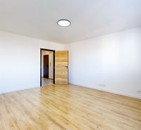 Ein leerer Raum mit Holzboden in einer 3-Zimmer-Wohnung.