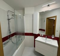 Badezimmer mit Badewanne, Spiegel und Waschbecken in einer 3-Zimmer-Wohnung.