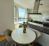 Küche in einer 3-Zimmer-Wohnung mit rundem Tisch und Aussicht, Boden mit Holzdekor.