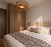 Schlafzimmer in einer 2-Zimmer-Wohnung mit Bett, Kleiderschrank und Boden in Holzoptik.