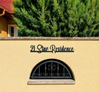 Gelbe Wand eines Einfamilienhauses in Darnózseli mit Schriftzug und dekorativem Fenster.