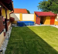 Der Garten eines Einfamilienhauses in Darnózseli mit Rasen und Pool, umgeben von einem Zaun.