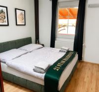 Schlafzimmer mit Doppelbett, Holzboden, Wanddekorationen.