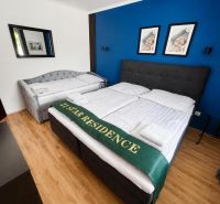 Ein Schlafzimmer in einem Einfamilienhaus mit einem Holzboden und einer dunkelblauen Wand.