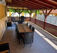 Eine gedeckte Terrasse eines Einfamilienhauses in Darnózseli mit Grill und bequemen Sitzgelegenheiten.