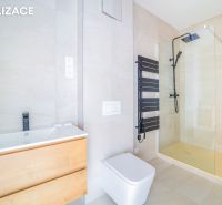 Badezimmer in einer Ferienwohnung mit dunklem Heizkörper und Duschkabine.