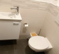 Badezimmer im Büro mit Waschbecken, Toilette und Wandverkleidung.