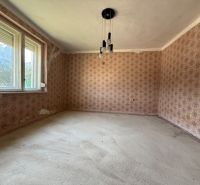 Ein Zimmer in einem Einfamilienhaus mit Blumen-Tapete und großen Fenstern.
