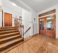Innenraum eines Einfamilienhauses mit Treppe, Fliesen und Wanddekorationen.