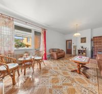 Wohnzimmer in einem Einfamilienhaus mit bequemen Möbeln und einem Boden in Holzoptik.
