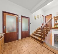 Der Flur eines Einfamilienhauses mit einem Holzgeländer und Dekorationen an den Wänden.