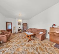 Wohnzimmer in einem Einfamilienhaus mit Ledersofa, Klavier und Holzboden.