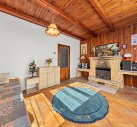 Innenraum eines Einfamilienhauses mit Kamin, Holzboden und Teppich.
